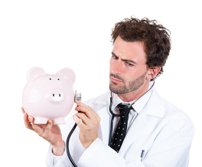 Closeup portrait, young curious male man healthcare professional, doctor, nurse listening to piggy bank with stethoscope. Medical insurance, medicare reimbursement concept . Health-law coverage gap
