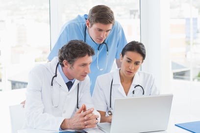 Team of doctors working on laptop computer in medical office